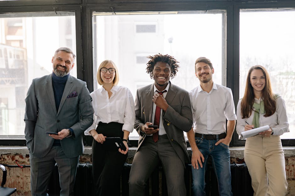 A diverse group of business professionals smiling and standing together in the office