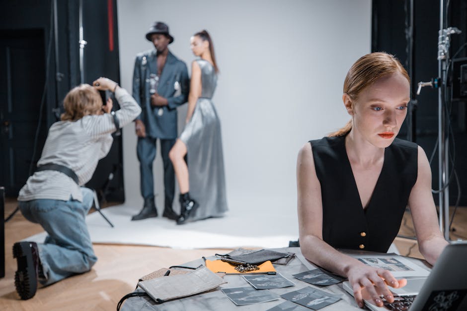 Photographer capturing fashion models during a professional photoshoot in a modern studio setting.